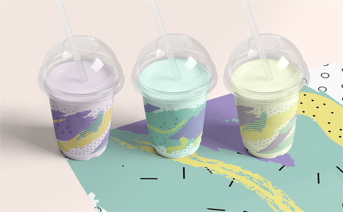 ba hộp sữa bong bóng màu phấn trong cốc nhựa, với thiết kế memphis trên thành cốc