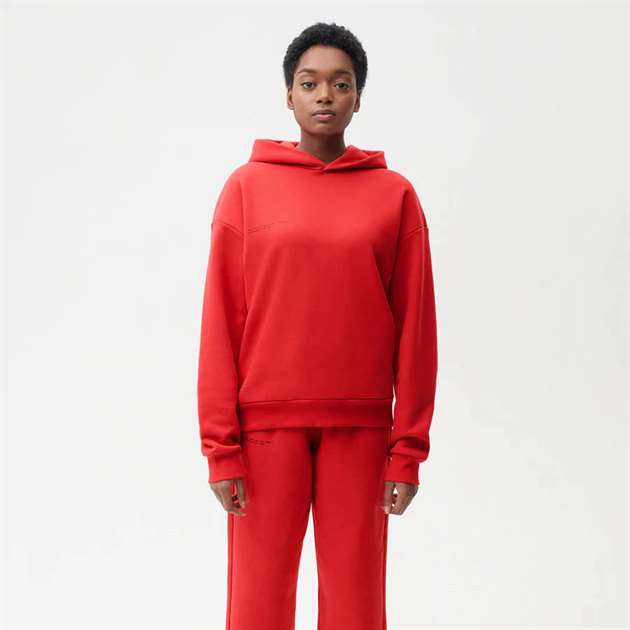 Một người mẫu mặc một chiếc áo len màu đỏ trên nền đơn giản