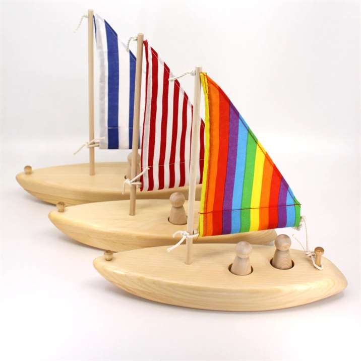 Ba chiếc thuyền buồm đồ chơi bằng gỗ với những cánh buồm đầy màu sắc