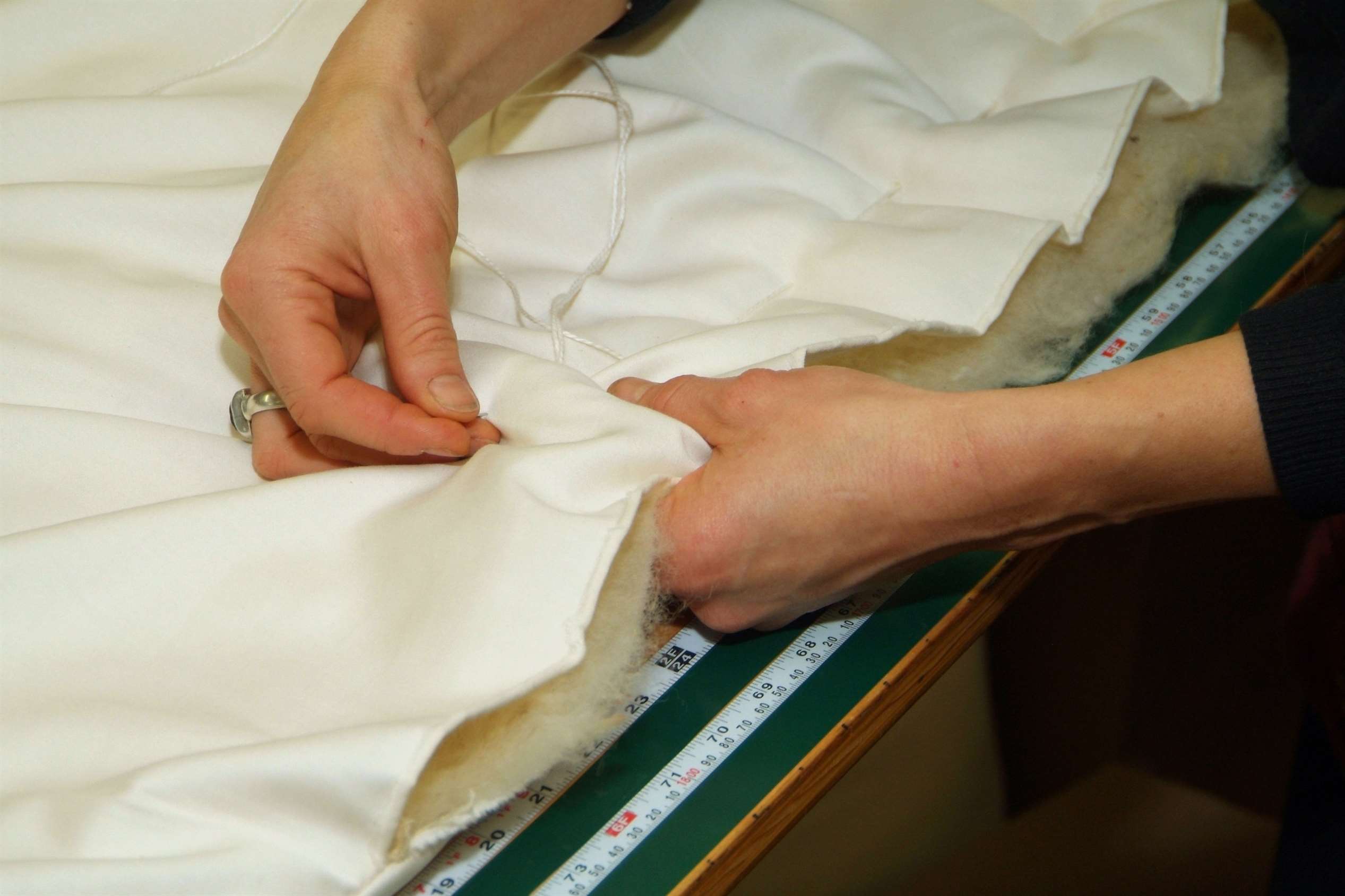 Một người thợ may một bộ đồ giường tại Holy Lamb Organics.