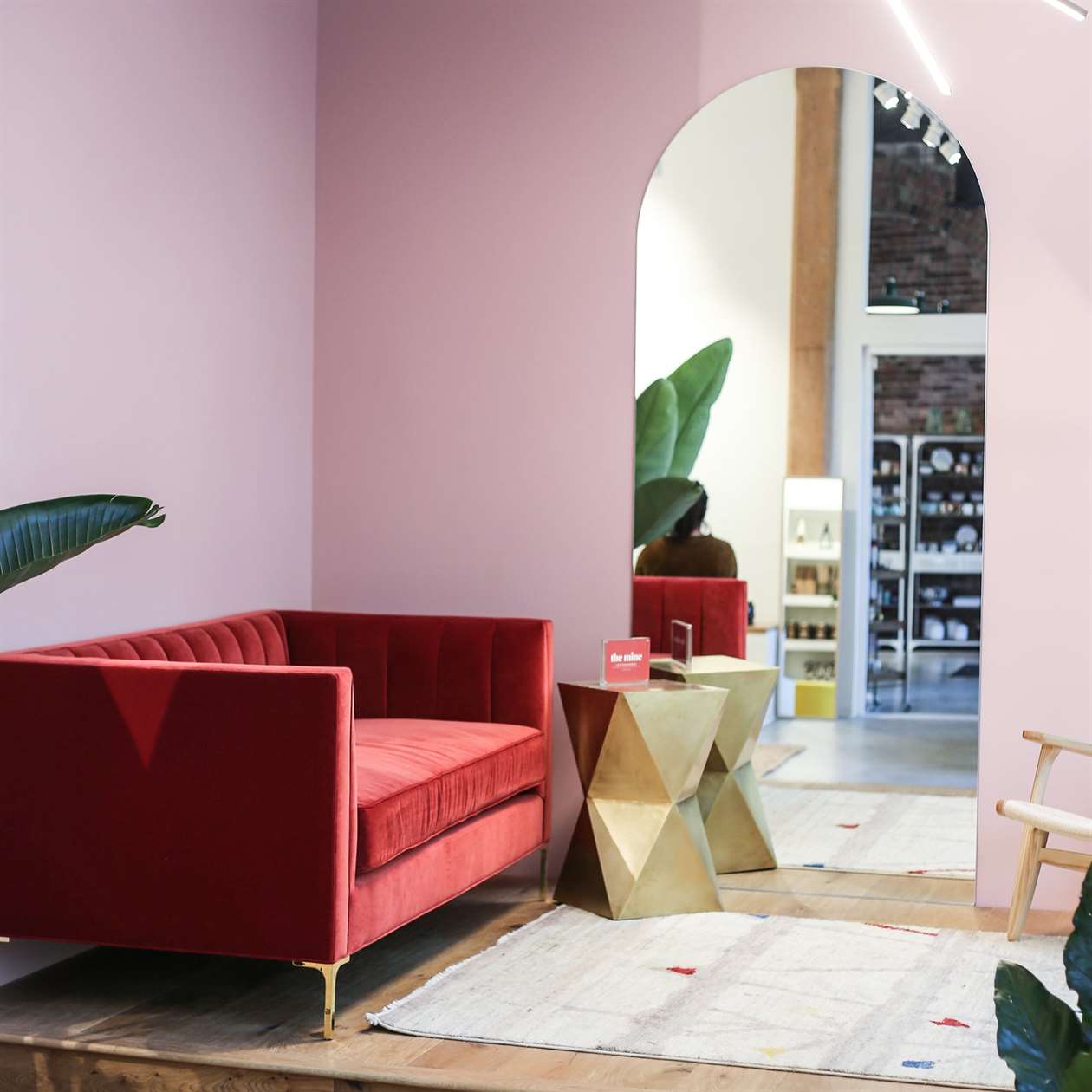 Nội thất của một cửa hàng với những bức tường màu hồng và một chiếc ghế dài màu đỏ