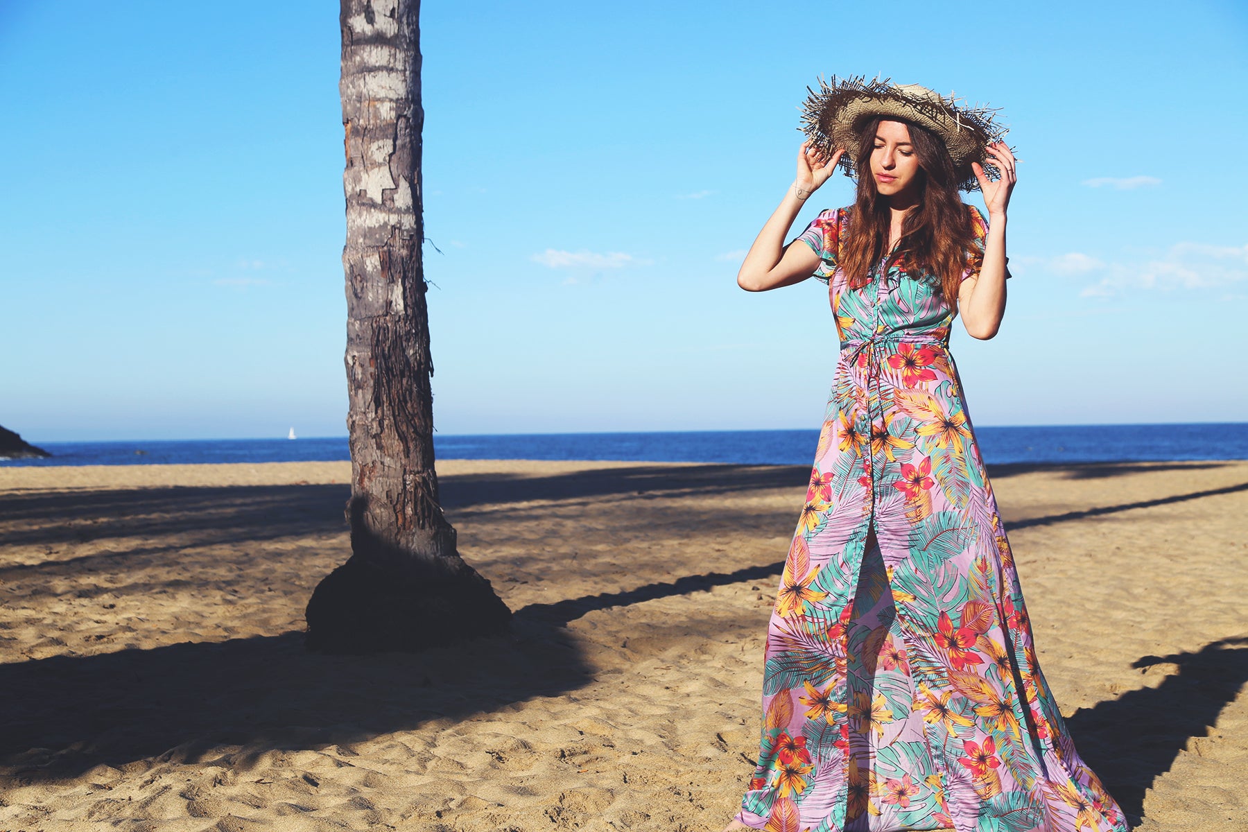 Một chiếc váy màu được Yana Dales, người sáng lập TAMGA Designs, làm mẫu trên bãi biển.